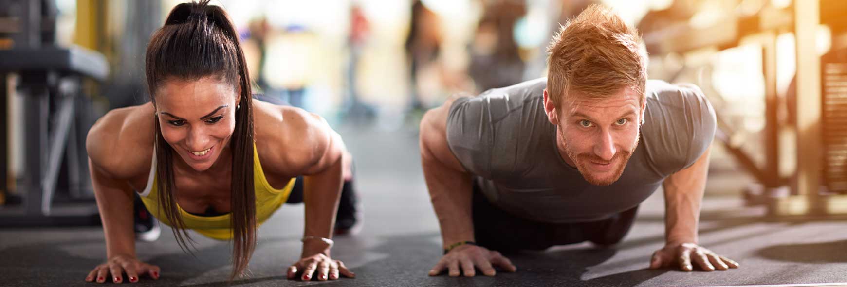 Man and woman performing resistance training exercises